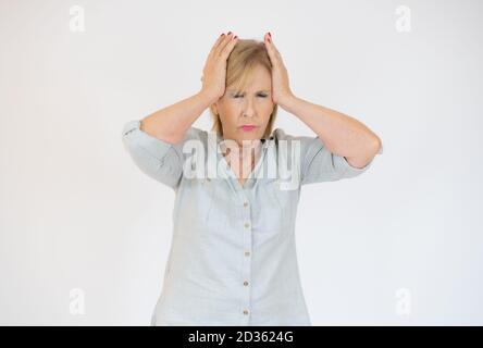 Donna anziana che ha mal di testa e che tocca i suoi templi isolati su sfondo bianco. Foto Stock