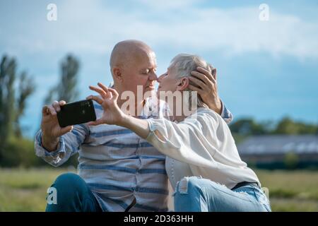 felice datazione di coppia senior, prendendo selfie e divertirsi all'aperto Foto Stock