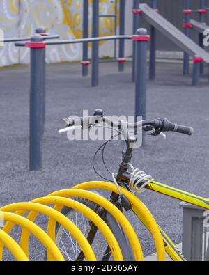 Manubrio e telaio di una bicicletta sportiva legati ad una parcheggio vicino a un'area di allenamento Foto Stock