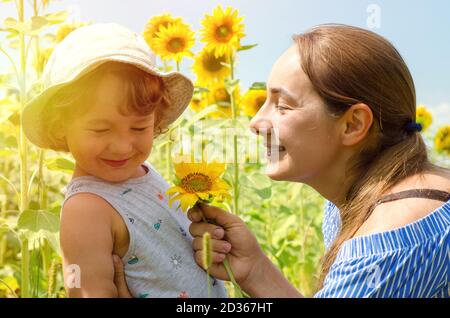 madre e bambino in campo girasoli Foto Stock