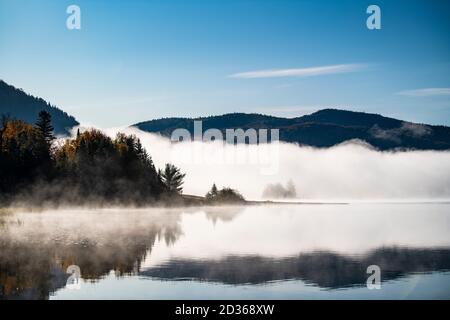 Fredda mattina nebbia oltre il bellissimo lago in autunno Foto Stock