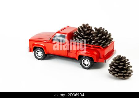 Coni di pino in rosso trendy tronco pick-up. Camion giocattolo e coni di pino. Parte del set. Foto Stock