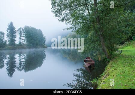 Lago Misty al mattino con barca e casa. In Passau Germany.A città in bassa Baviera Dreiflüssestadt o Città di tre fiumi - Danubio. Canoe Foto Stock