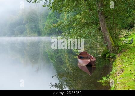 Lago Misty al mattino con barca e casa. In Passau Germany.A città in bassa Baviera Dreiflüssestadt o Città di tre fiumi - Danubio. Canoe Foto Stock