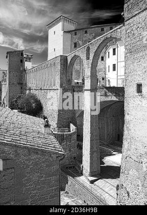 Lo spettacolare acquedotto mediceo della città di Pitigliano, costruito con rocce tufo, e la torre di Palazzo Orsini alle sue spalle che sorge verso il cielo. Foto Stock