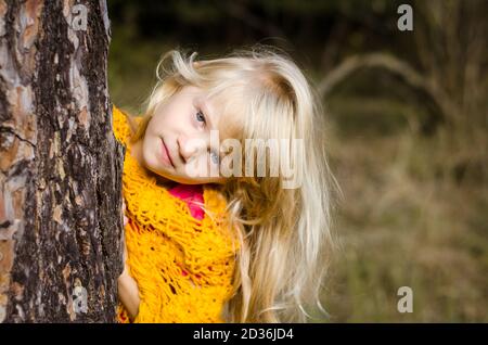 adorabile ragazza con lunghi capelli biondi nel pomeriggio soleggiato in il legno Foto Stock