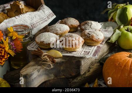 Deliziosi muffin di zucca fatti in casa cosparsi di zucchero a velo su sfondo scuro, prodotti da forno per Halloween Foto Stock