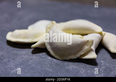 Gnocchi polacchi senza glutine (Pierogi), piatto nazionale lucidato fatto di pasta e ripieno salato o dolce. Vista ravvicinata di diversi gnocchi surgelati lisi Foto Stock