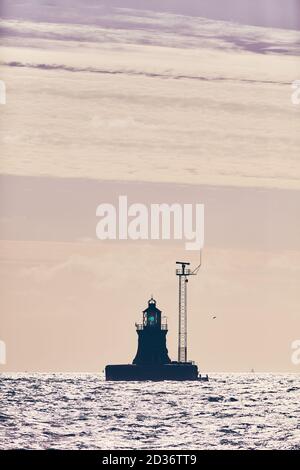 Silhouette di un beacon al tramonto, messa a fuoco selettiva, tonalità colore applicate. Foto Stock