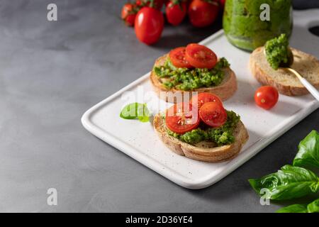 bruschetta fatta in casa con pesto fresco e pomodori ciliegini Foto Stock