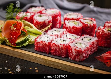 Primo piano sushi giapponese set con caviale rosso di pesce volante. Zenzero sottaceto, pasta di wasabi piccante e salsa di soia. Foto Stock