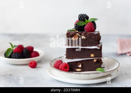 pezzi quadrati di brownie al cioccolato con nocciole e frutti di bosco Foto Stock