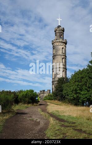 Monumento Nelson sulla collina di Calton in un giorno con le nuvole e il cielo blu, Edimburgo, Scozia Foto Stock