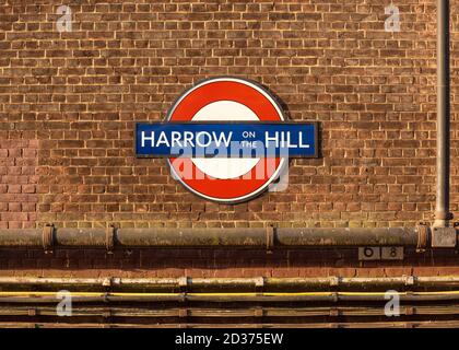 Harrow on the Hill Roundel segno della metropolitana su un muro di mattoni, Greater London, UK Foto Stock