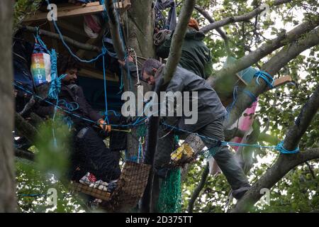 Aylesbury vale, Regno Unito. 6 ottobre 2020. Daniel Marc Hooper (r), meglio conosciuto come swampy, si unisce ai suoi compagni anti-HS2 protezione degli alberi in e intorno a una casa di albero di fortuna circa sessanta piedi sopra terra in un campo di protezione della fauna selvatica in antico bosco a JonesÕ Hill Wood. Il campo di JonesÕ Hill Wood, uno dei numerosi campi di protesta allestiti da attivisti anti-HS2 lungo il percorso del £106bn HS2 collegamento ferroviario ad alta velocità per resistere al controverso progetto infrastrutturale, è attualmente sfratto dai Bailiffs del National Eviction Team che lavorano per conto di HS2 Ltd. Credit: Mark Kerrison/Alamy Live News Foto Stock