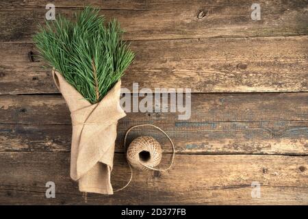Bouquet con rami di abete su sfondo naturale di legno. Foto Stock