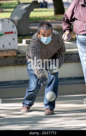 Un uomo, probabilmente italiano americano che lancia una palla in una partita di bocce, in un parco a Flushing, Queens, New York City. Foto Stock