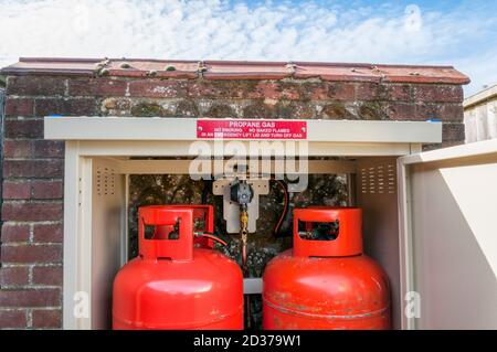 Installazione di gas calorici domestici di gas di petrolio liquefatto, GPL, barattoli in un armadio sicuro bloccabile. Utilizzato in aree rurali lontano dalla rete di alimentazione di gas. Foto Stock