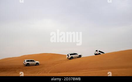 Fuoristrada che arrampicano sulle dune di sabbia a Dubai Foto Stock