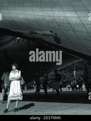 Donna in bianco in attesa impazientemente da Cloud Gate a Chicago, Illinois Foto Stock