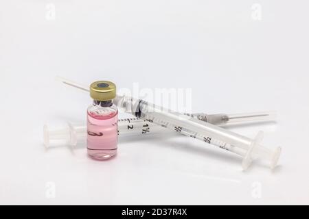 Flacone di vaccino isolato in vetro con liquido colorato e vuoto due siringhe Foto Stock