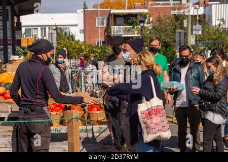 Montreal, CA - 4 ottobre 2020: Venditore di mercato e clienti che indossano maschere Coronavirus al mercato Marche Jean Talon Foto Stock