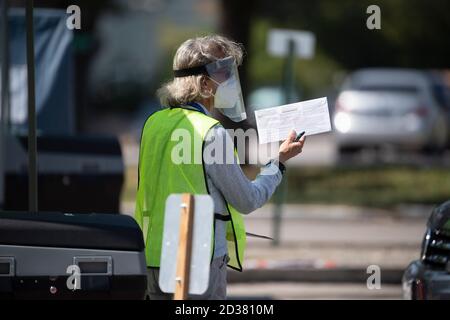 Austin, TX USA 7 ottobre 2020: I funzionari delle elezioni della contea di Travis ricevono i voti per posta nell'unica struttura di raccolta autorizzata della contea una settimana prima dell'inizio delle elezioni del 2020 novembre. Gli elettori mostrano un documento d'identità con foto, firmano una ledger e osservano come il loro scrutinio è caduto in una scatola sicura del voto. Credit: Bob Daemmrich/Alamy Live News Foto Stock