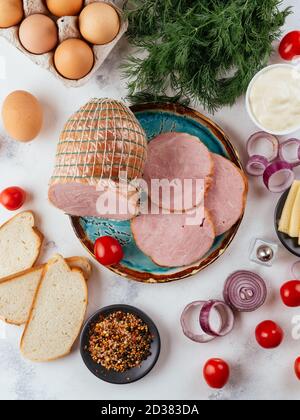 salsiccia fresca fatta in casa su uno sfondo chiaro con verdure Foto Stock