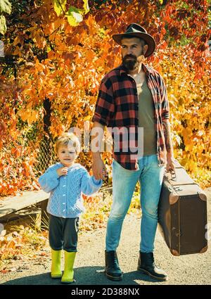 Raccontare storie sui tempi passati. Padre con valigia e suo figlio. Papà sopportato che dice al figlio di viaggiare. Viaggiatori con molta esperienza. Spirito di Foto Stock