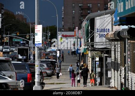 I clienti si fanno strada lungo la 108th Street nel quartiere di Forest Hills, designata "zona rossa", Queens, NY, 7 ottobre 2020. Gov. Andrew Cuomo ha adottato un sistema di zone colorate a tre livelli (giallo, arancione e rosso), piuttosto che utilizzare i codici di avviamento postale, per identificare i quartieri che stanno vedendo un picco significativo nelle infezioni da Coronavirus, e imporre diverse restrizioni in base al colore della zona, il rosso essendo il più alto. Le restrizioni della zona rossa includono un massimo di 10 persone all'interno delle case di culto, sono vietate le riunioni di gruppo, solo le imprese essenziali possono rimanere aperte, le scuole in re Foto Stock