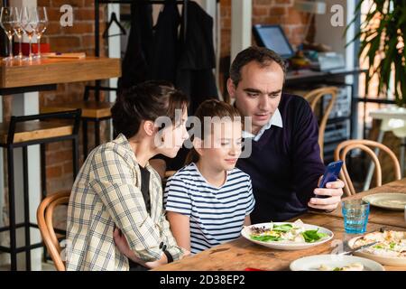 Una famiglia felice di tre selfie in un caffè. Foto Stock