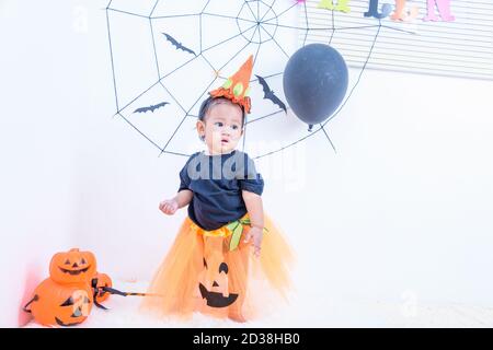 Divertente ragazza felice del bambino in costume di Halloween con Jack della zucca Con Cobweb sullo sfondo Foto Stock