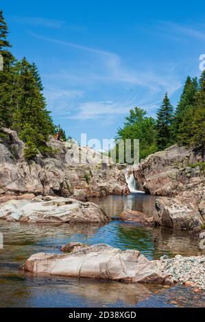 Coppia escursionistica riposante su una scogliera sopra Broad River. Cascate e piscine lungo il torrente. Moosehorn Trail, Fundy National Park, New Brunswick, Canada Foto Stock