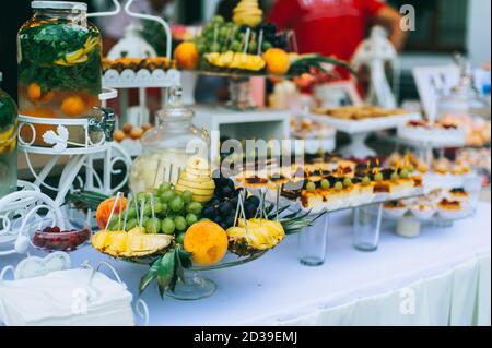 Frutta fresca diversa sul tavolo del buffet di nozze. Decorazione di tabella di nozze. Buffet di frutta alla reception. Tavolo per ricevimenti nuziali con diverse fru Foto Stock