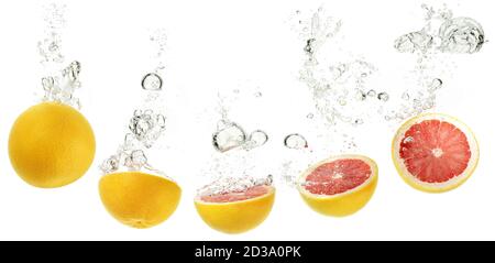 arance rosse che cadono in acqua su sfondo bianco Foto Stock