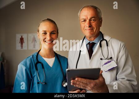 Ritratto del medico caucasico femminile e maschile con compressa digitale Foto Stock