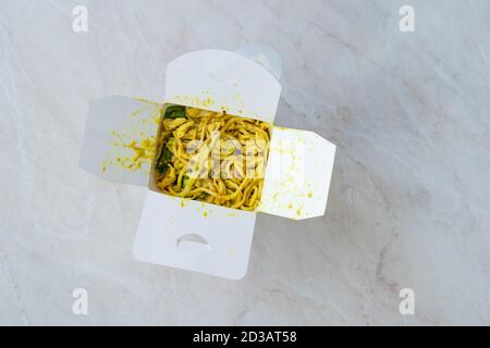 Take away Satay Noodle con salsa di curry, curcuma e burro di arachidi in plastica scatola Confezione / contenitore. Pronto per la consegna. Foto Stock