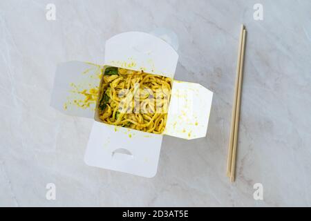 Take away Satay Noodle con salsa di curry, curcuma e burro di arachidi in plastica scatola Confezione / contenitore. Pronto per la consegna. Foto Stock