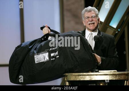 Film critic Joel Siegel holds a celebrity gift bag during the 10th Annual Critic's Choice Awards at the Wiltern Theater in Los Angeles, California January 10, 2005. Organisers of the awards and celebrities are signing their gift bags, which will be used to raise funds for victims of the December 26 Asian tsunami. REUTERS/Robert Galbraith  SSM/FA