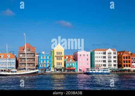 Curacao, Willemstad, Vista della Baia di St Anna che guarda verso le case mercantili coloniali che costeggiano Handelskade lungo il lungomare di Punda Foto Stock