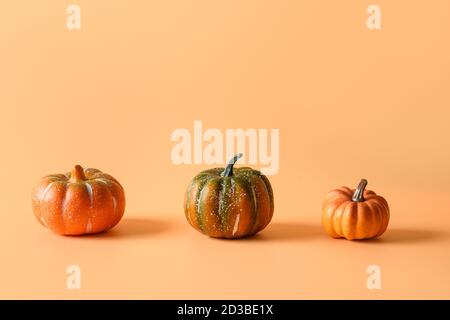 Giorno di ringraziamento o Halloween tre diverse zucche su sfondo arancione. Spazio per testo o disegno. Foto Stock