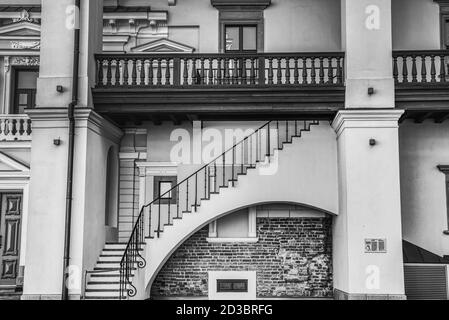La facciata dell'edificio pomposo del Palazzo dei Granduchi di Lituania presenta scale su un arco sotto un balcone con corrimano in legno. Vilnius, Lituania Foto Stock