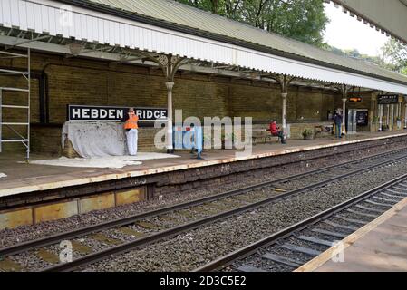 Pittori e decoratori che lavorano sulla piattaforma alla stazione ferroviaria di Hebden Bridge, Yorkshire, Regno Unito Foto Stock