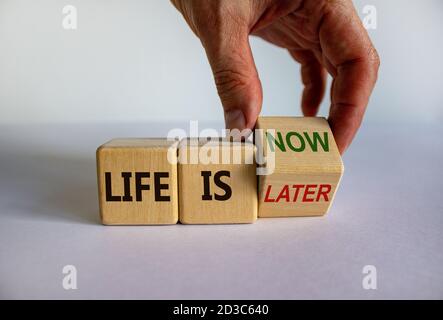 La mano trasforma un cubo e cambia l'espressione "la vita è più tardi" in "la vita è ora". Splendido sfondo bianco, spazio per la copia. Concetto di stile di vita. Foto Stock