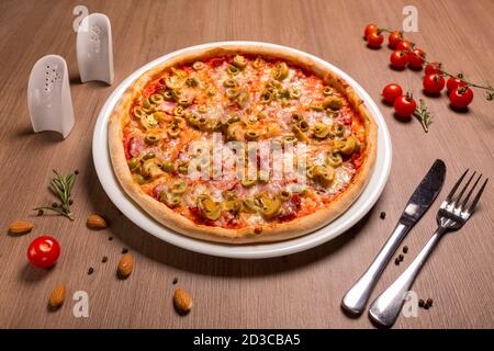 Capricciosa pizza torta sottile, pomodoro, olive, funghi, mozzarella, basilico Foto Stock
