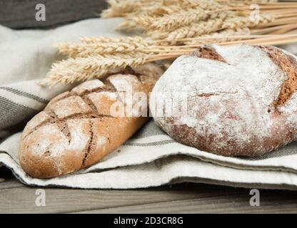 Assortimento di pane cotto e grano sul legno Foto Stock