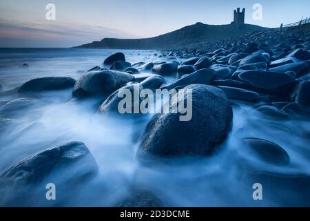 Dunstanburgh Castle da Embleton Bay, Embleton, Northumberland poco prima dell'alba. Primavera (aprile 2019) Foto Stock