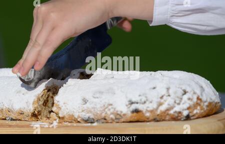 Dresda, Germania. 8 ottobre 2020. Johanna Meitzner, la 26a Dresden Stollen Girl, taglia il primo Stollen di Natale durante la sua esibizione nel Pillnitz Palace Park. L'apprendista fornaio di 21 anni è l'ambasciatore dello Stollen di Natale di Dresda per la durata di un anno per conto dei panifici Stollen di Dresda. Credit: Robert Michael/dpa-Zentralbild/dpa/Alamy Live News Foto Stock