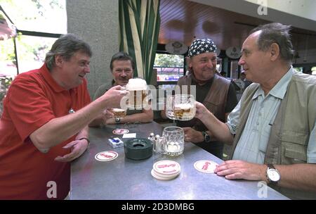 Bevitori di birra nella famosa birreria all'aperto presso la Fiera del Prater Fun e la Grande ruota panoramica, dove vengono servite grandi porzioni di maiale Foto Stock