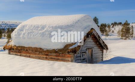 STRYN, NORVEGIA - 2018 MARZO 29. Cottage con un sacco di neve sul tetto. Foto Stock